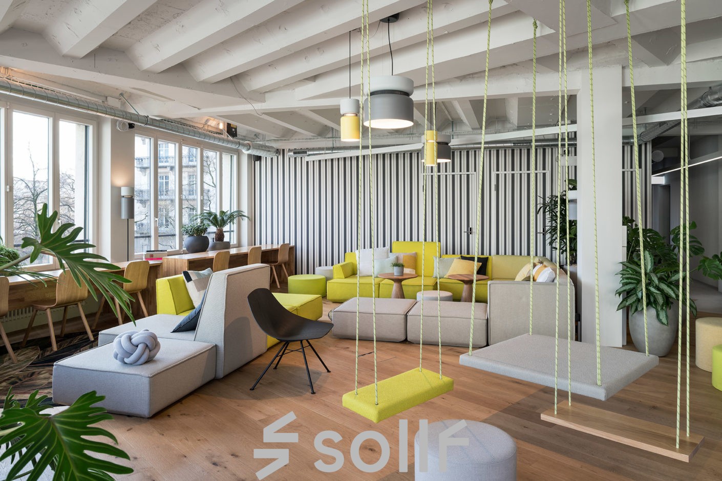 Modern gestalteter Lounge-Bereich im Büro in Talacker 41, Zürich City, mit bequemen Sitzmöglichkeiten und Pflanzen.
