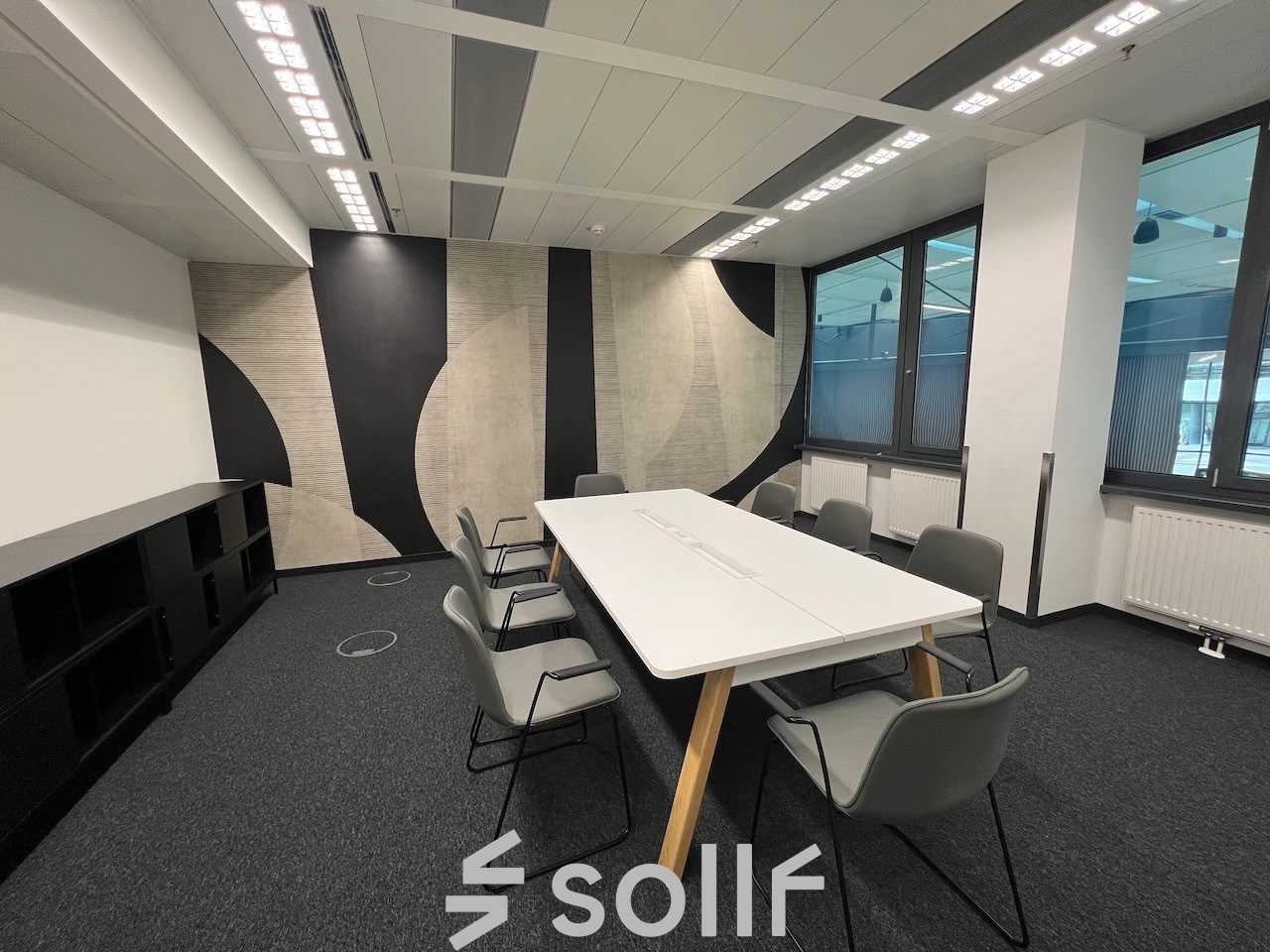 Modern office space rental at Am Euro Platz 2, 1120 Vienna Meidling, with a sleek white table, comfortable chairs, and stylish geometric wall design.