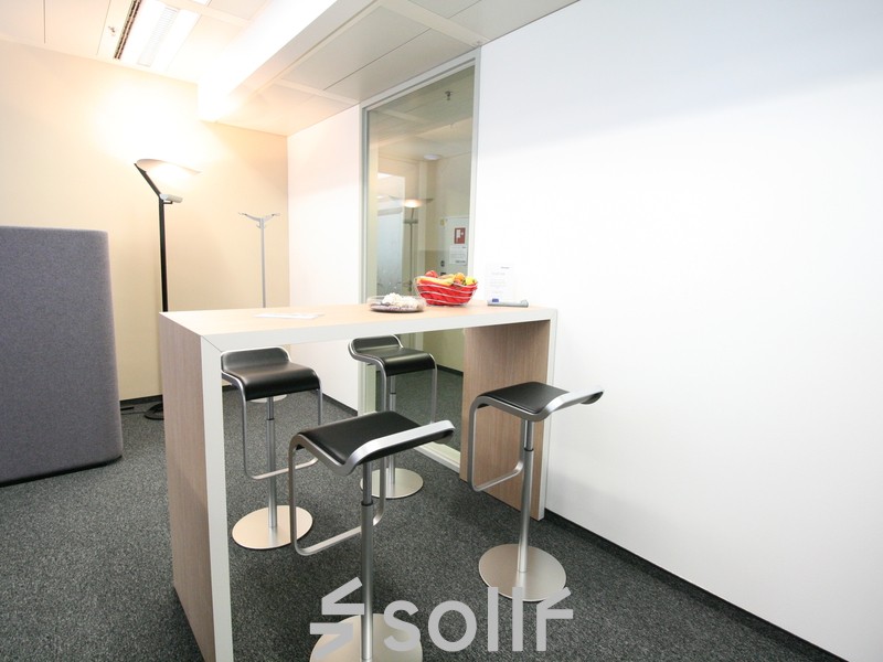 Modern office space rental at Am Euro Platz 2, 1120 Vienna (Meidling), with high stools and a sleek counter for collaborative work.