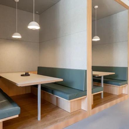 Moderne Büroraum mieten in Genf Les Genets, Rue du Pré-de-la-Bichette 1, mit Holzmöbeln und komfortabler Sitzbank.