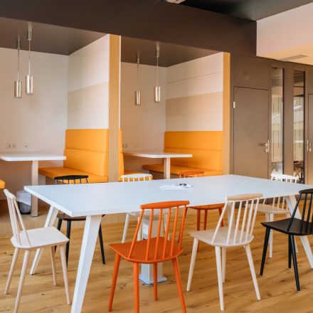 Modern gestalteter Büroraum zum Mieten auf der Waagner-Biro-Straße 47 in Graz mit Holzboden und farbenfrohen Möbeln.