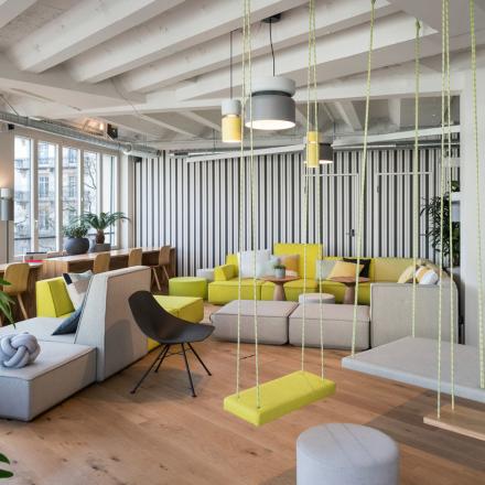 Modern gestalteter Lounge-Bereich im Büro in Talacker 41, Zürich City, mit bequemen Sitzmöglichkeiten und Pflanzen.